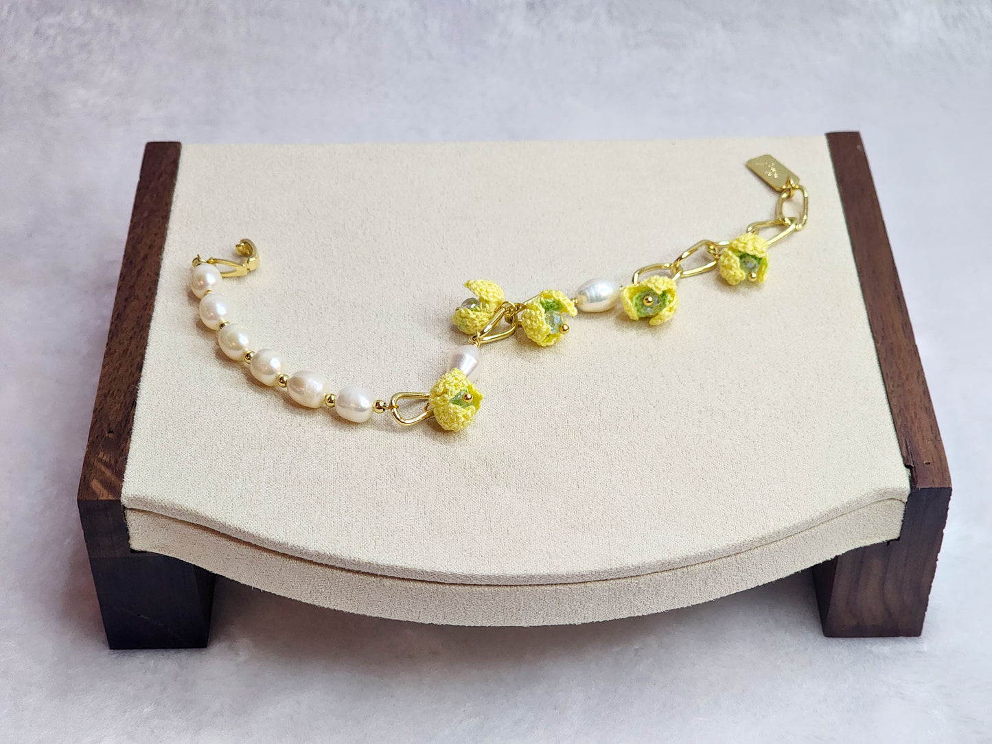 Luminous pearl bracelet with 18K gold-plated chain links on which micro-crochet snowdrops hang.
