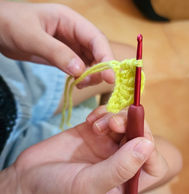 A student learning to crochet