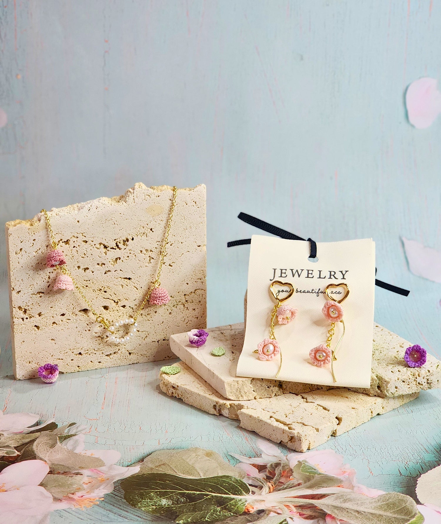 Lily of the Valley Collection featuring micro-crochet accessories with pearls. Featured a pearl necklace with pink micro-crochet Lilies of the Valley and earrings. 18K gold-plated.