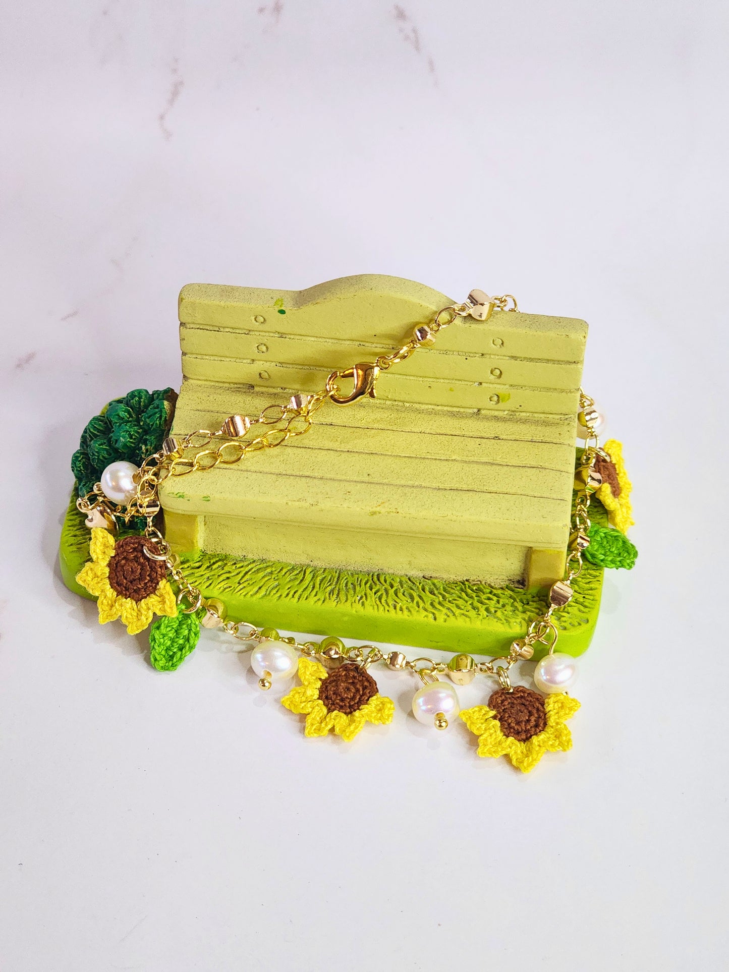 Handcrafted micro-crochet sunflowers & pearls bracelet. 6-7mm oval freshwater pearls set on 14K gold-plated adjustable chain.