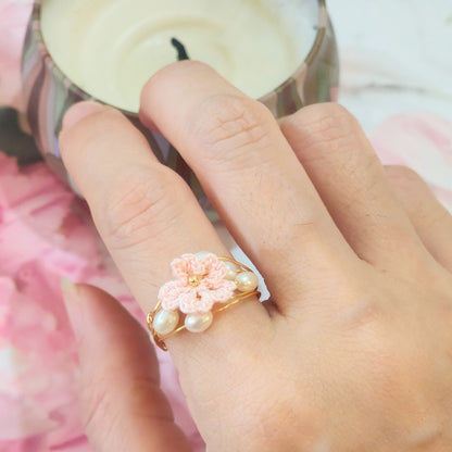 Natural 4-5mm Baroque pearls flank a handcrafted micro-crochet pink Sakura, on an 18K gold-plated ring.