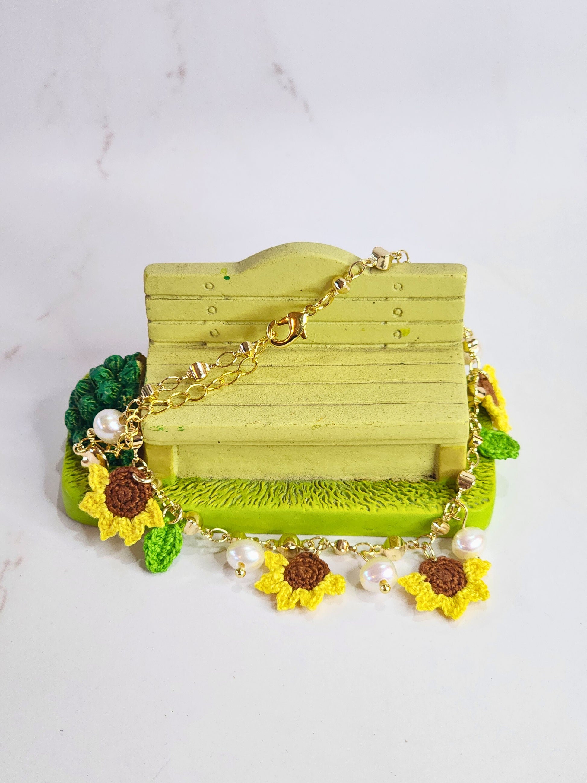 Handcrafted micro-crochet sunflowers & pearls bracelet. 6-7mm oval freshwater pearls set on 14K gold-plated adjustable chain.