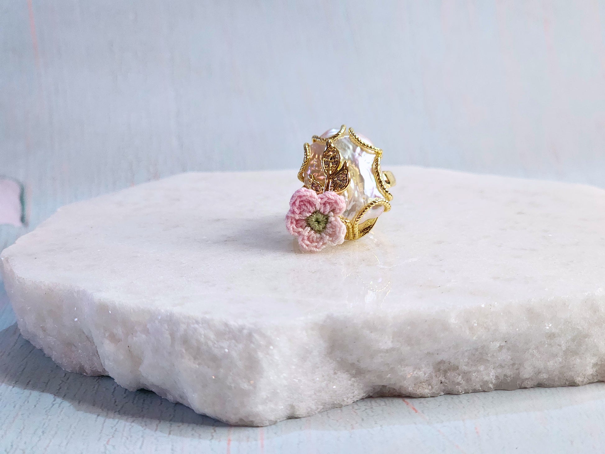 Natural Baroque pearl with a handcrafted micro-crochet apple blossom. 18K gold-plated setting. Adjustable ring.