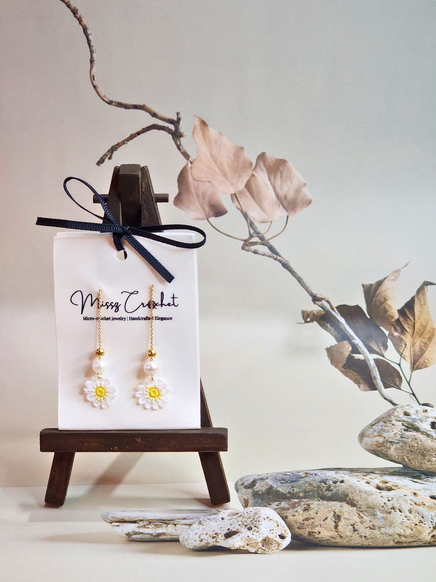 Handcrafted micro-crochet daisies earrings accented with freshwater pearls & gold beads. Styled with 18K gold-plated tassel hooks.