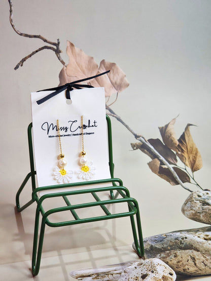 Handcrafted micro-crochet daisies earrings accented with freshwater pearls & gold beads. Styled with 18K gold-plated tassel hooks.  