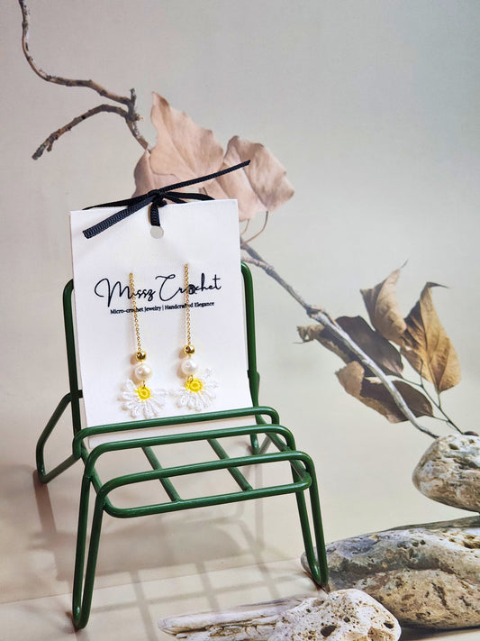Handcrafted micro-crochet daisies earrings accented with freshwater pearls & gold beads. Styled with 18K gold-plated tassel hooks.  