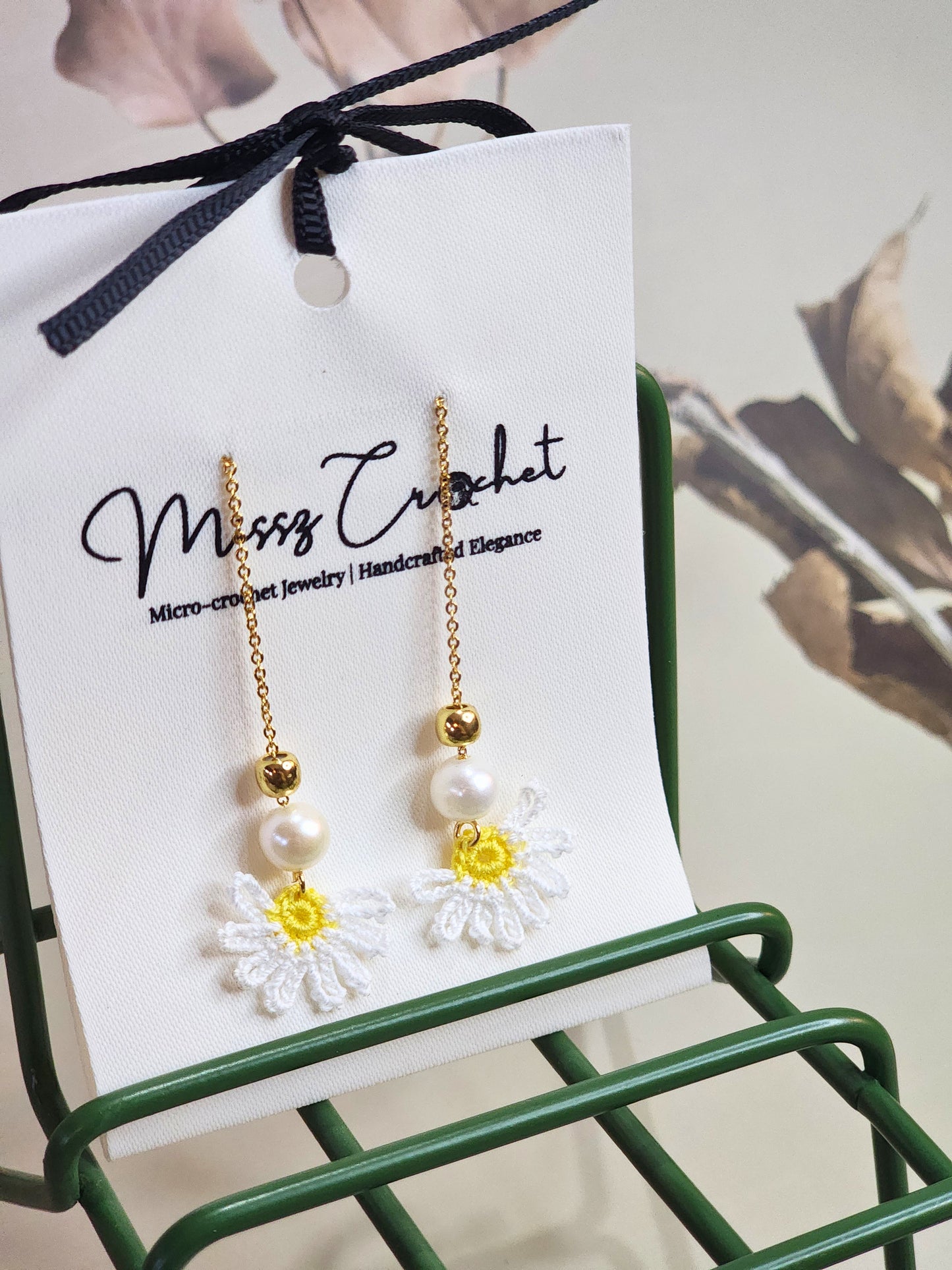 Handcrafted micro-crochet daisies earrings accented with freshwater pearls & gold beads. Styled with 18K gold-plated tassel hooks.  