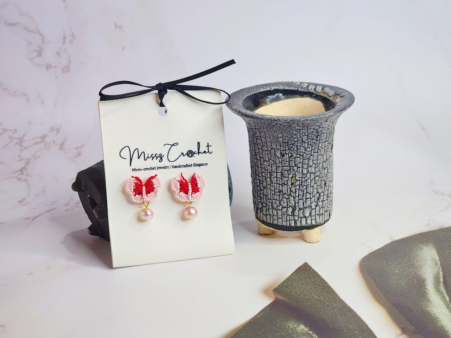 Handcrafted pink-red micro-crochet butterflies adorned with 6-7mm natural freshwater pearls. 18K gold-plated studs. 