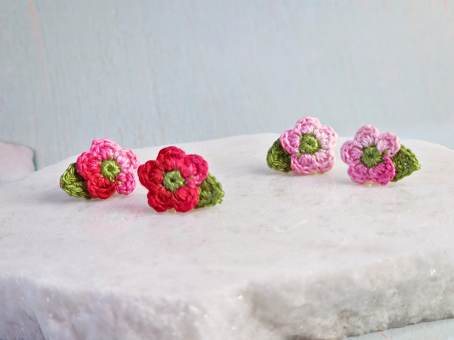 Handcrafted micro-crochet apple blossoms earrings in pink and red tones. On 18K gold-plated studs. 