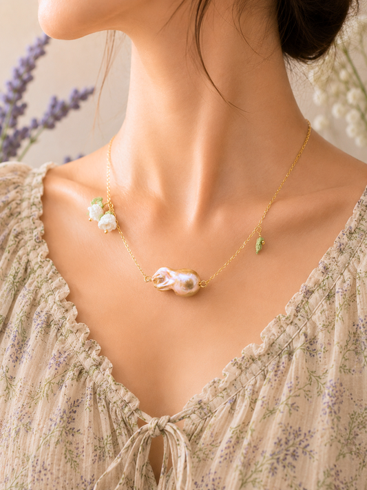 Suspended beneath two handcrafted micro crochet Lily of the Valley blooms is a captivating metallic purple-gold Baroque pearl. Each bloom is crowned with luminous 6mm Aurora pearls. On 18K gold-plated necklace chain. 