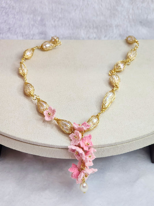 Baroque pearl gold twist necklace with a cascade of handcrafted pink micro-crochet peach blossoms.