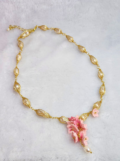 Baroque pearl gold twist necklace with a cascade of handcrafted pink micro-crochet peach blossoms.
