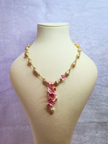 Baroque pearl gold twist necklace with a cascade of handcrafted pink micro-crochet peach blossoms.