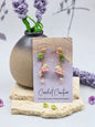 Handcrafted micro crochet Lily of the Valley blooms earrings. Paired with lustrous 6–8mm freshwater Aurora pearls and naturally formed 4–5mm pink-purple baroque pearls. 18K gold-plated.