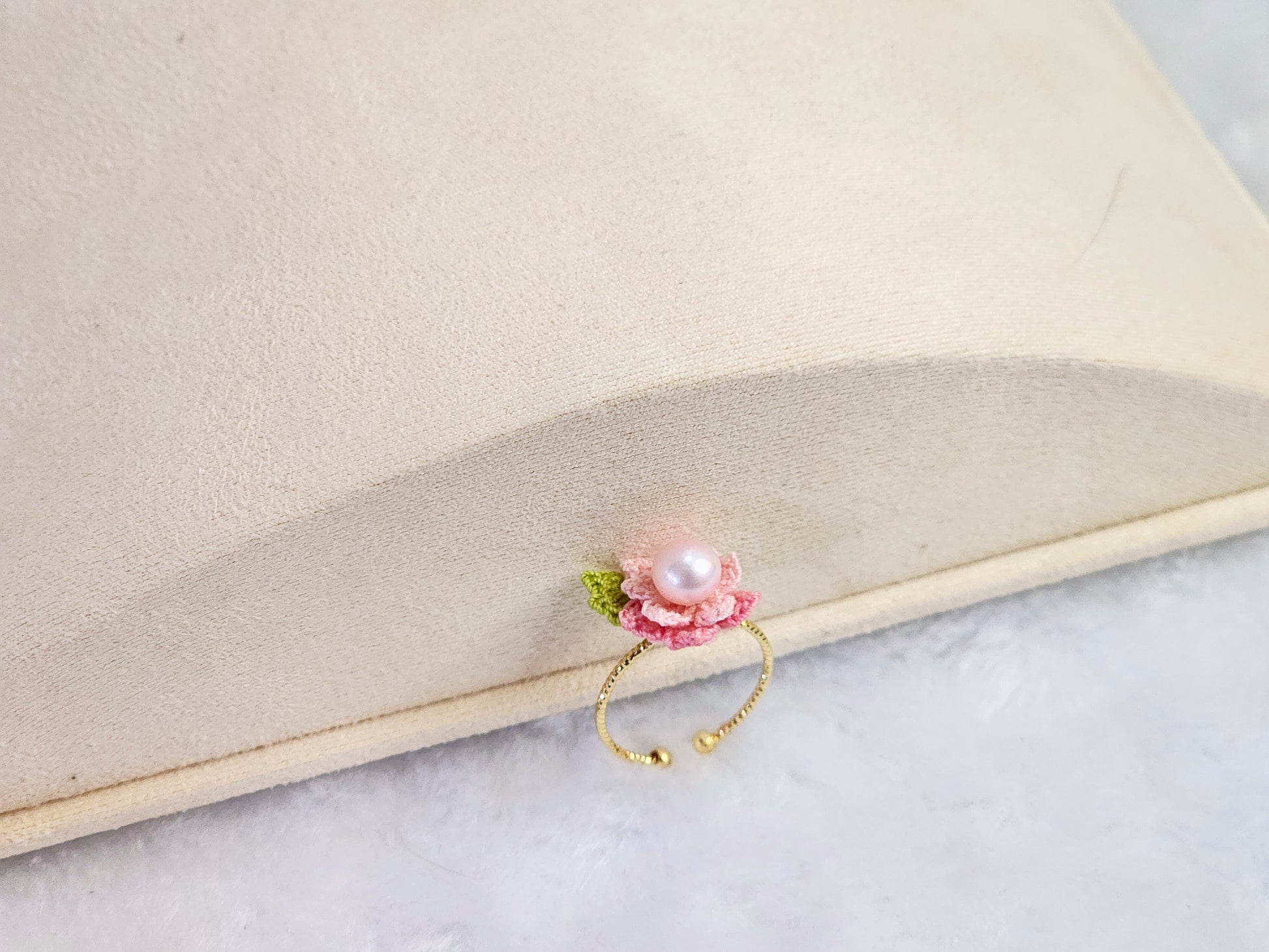 Lustrous pearl ring with pink handcrafted micro-crochet peach blossoms. 14K gold-plated adjustable ring.  