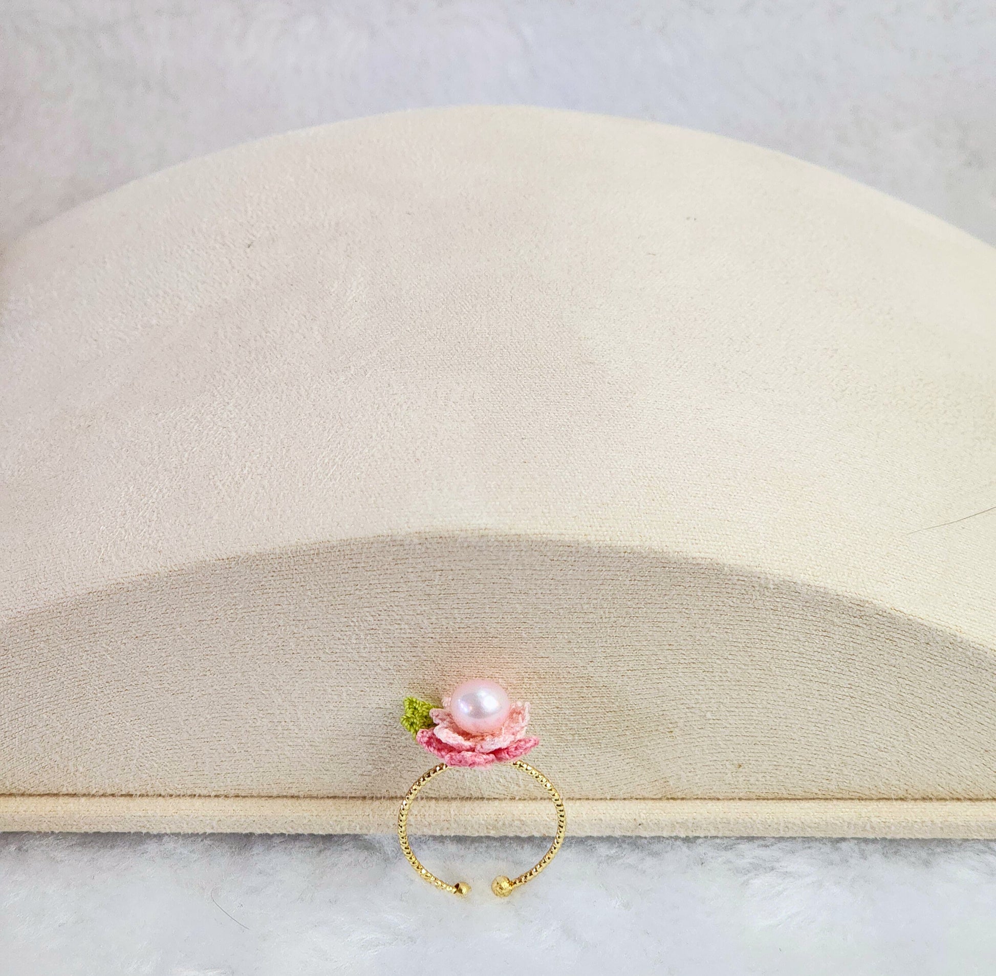Lustrous pearl ring with pink handcrafted micro-crochet peach blossoms. 14K gold-plated adjustable ring.  