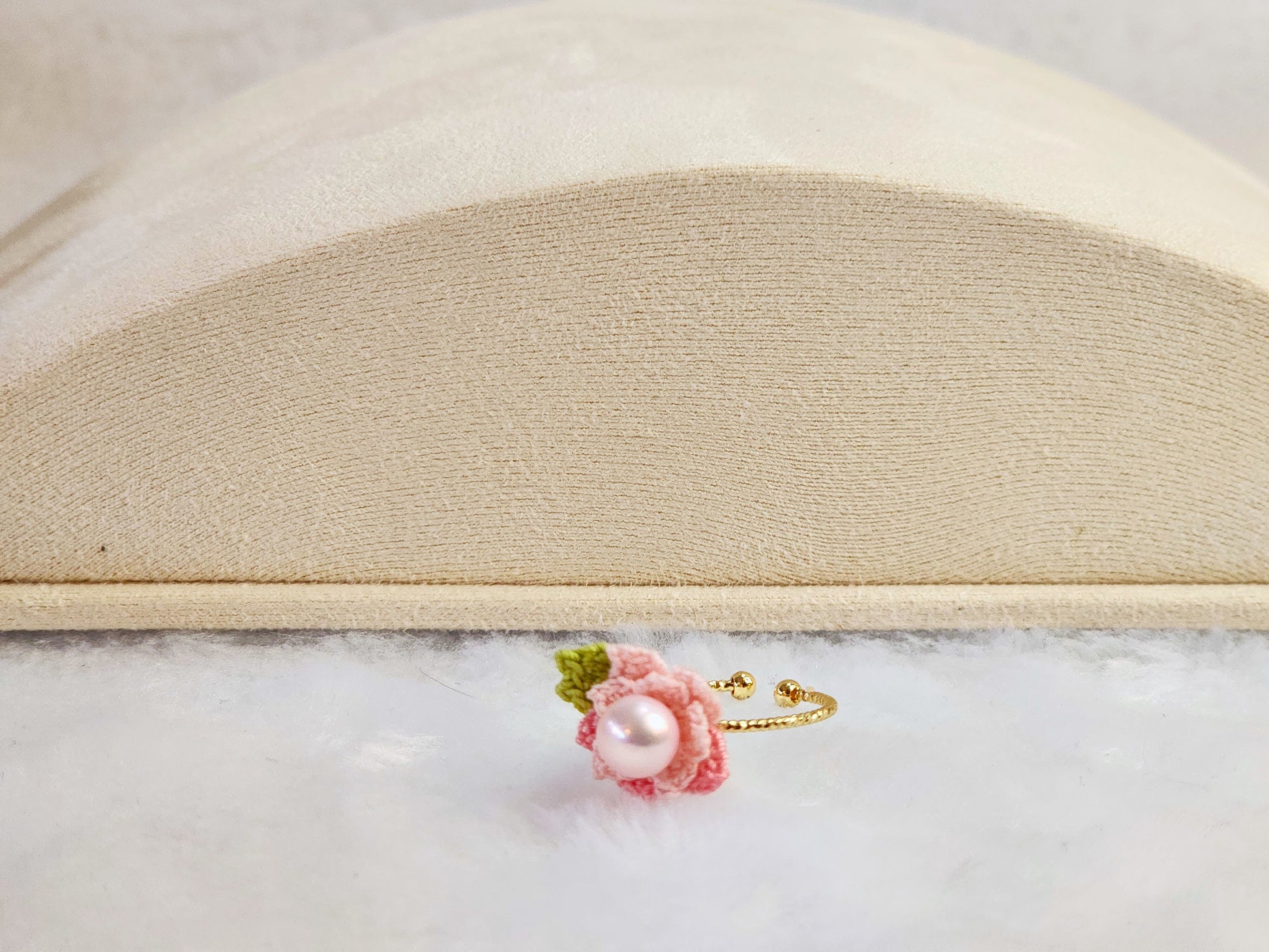 Lustrous pearl ring with pink handcrafted micro-crochet peach blossoms. 14K gold-plated adjustable ring. 