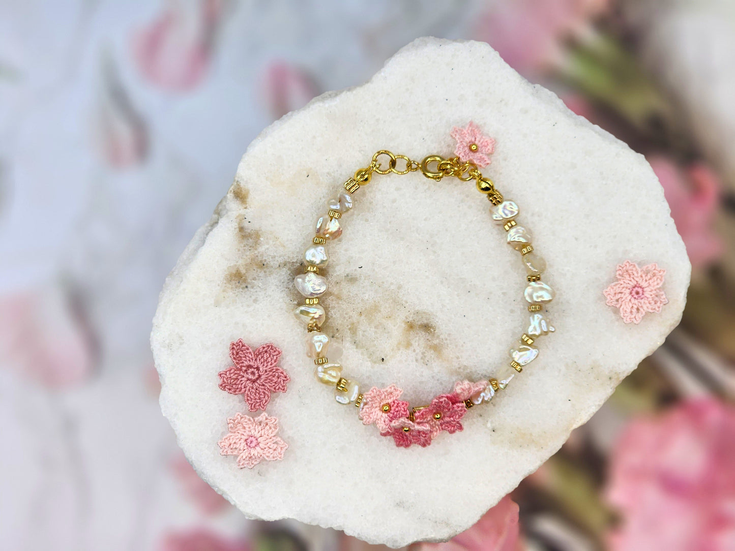 High-lustre Keshi pearls with gold-plated beads and micro crochet Sakura blossoms. 18K gold-plated jewelry wire, beads and chain clasp.