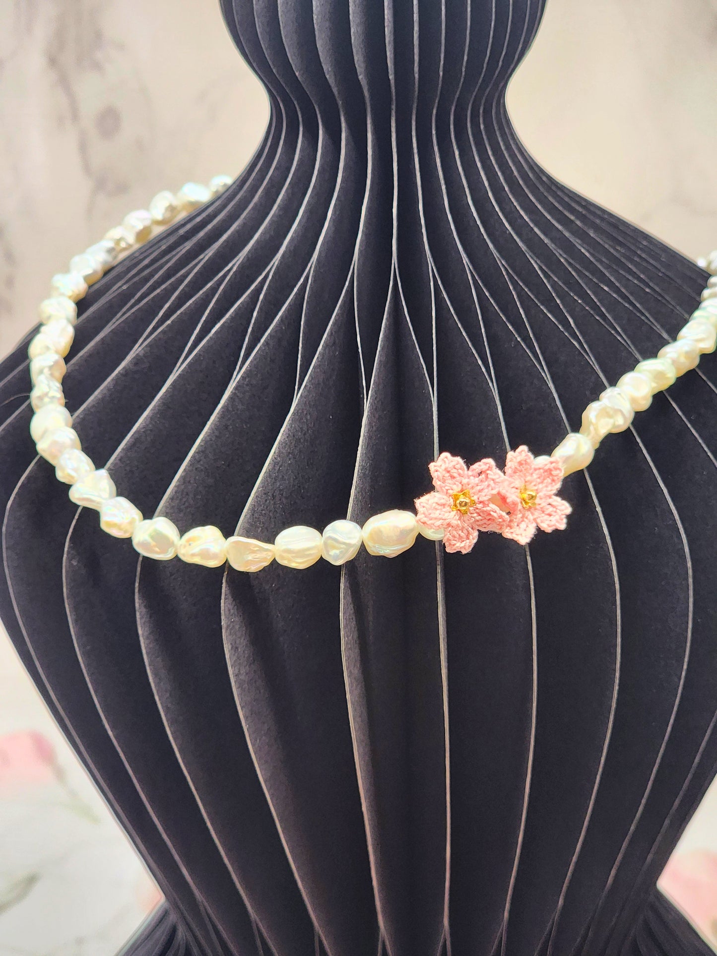 Full strand necklace. 6–7mm Keshi pearls, each one uniquely shaped and glowing with exceptional lustre. Accented with delicate micro crochet Sakura blossoms. 