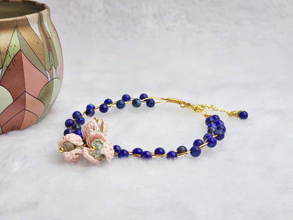 Natural Lapis Lazuli crystal bracelet with a cluster of micro-crochet snowdrops. On 14K gold-plated bangle with extension chain. 