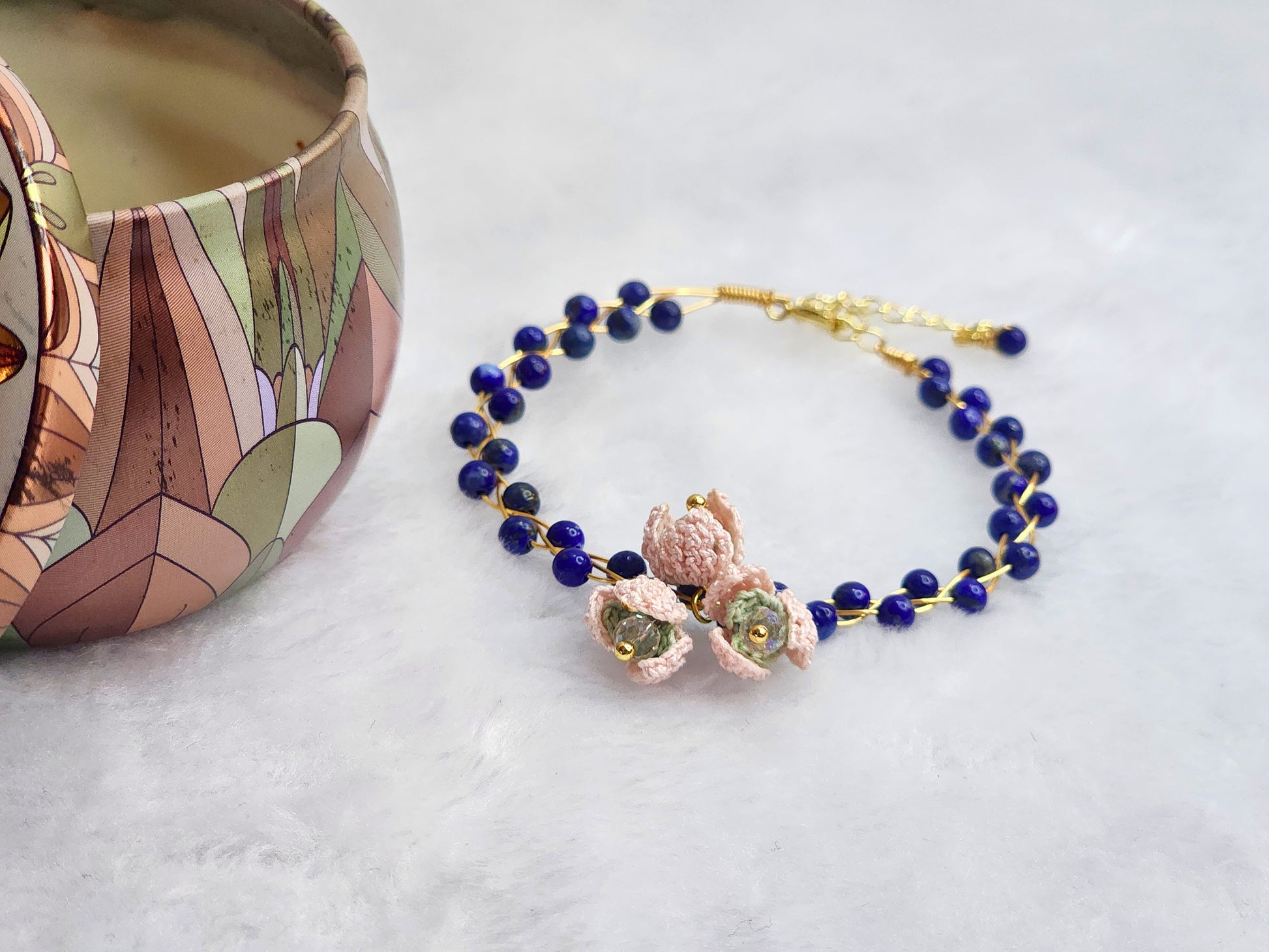 Natural Lapis Lazuli crystal bracelet with a cluster of micro-crochet snowdrops. On 14K gold-plated bangle with extension chain. 