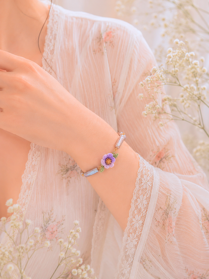 Handcrafted Lily of the Valley blooms bracelet, framing striking silver-grey Pipa pearls and an 8-9mm metallic Edison pearl. 18K gold-plated. 