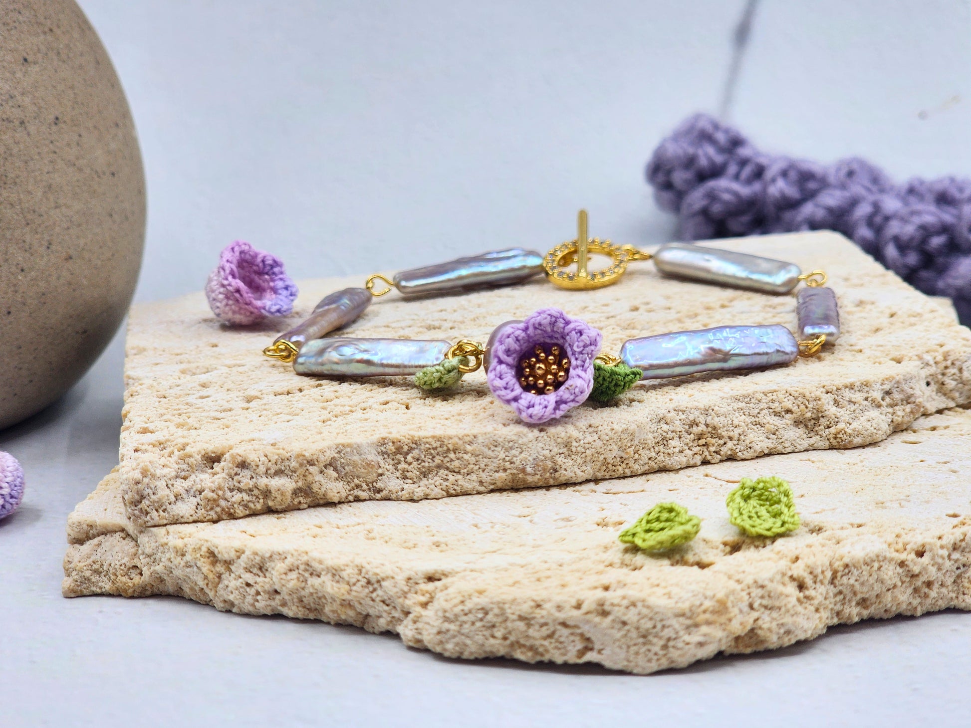 Handcrafted Lily of the Valley blooms bracelet, framing striking silver-grey Pipa pearls and an 8-9mm metallic Edison pearl. 18K gold-plated. 