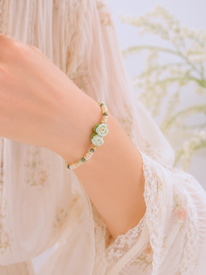 Handcrafted micro crochet Lily of the Valley blooms paired with radiant 4–5mm freshwater Keshi pearls bracelet. Natural Phoenix stones accents.