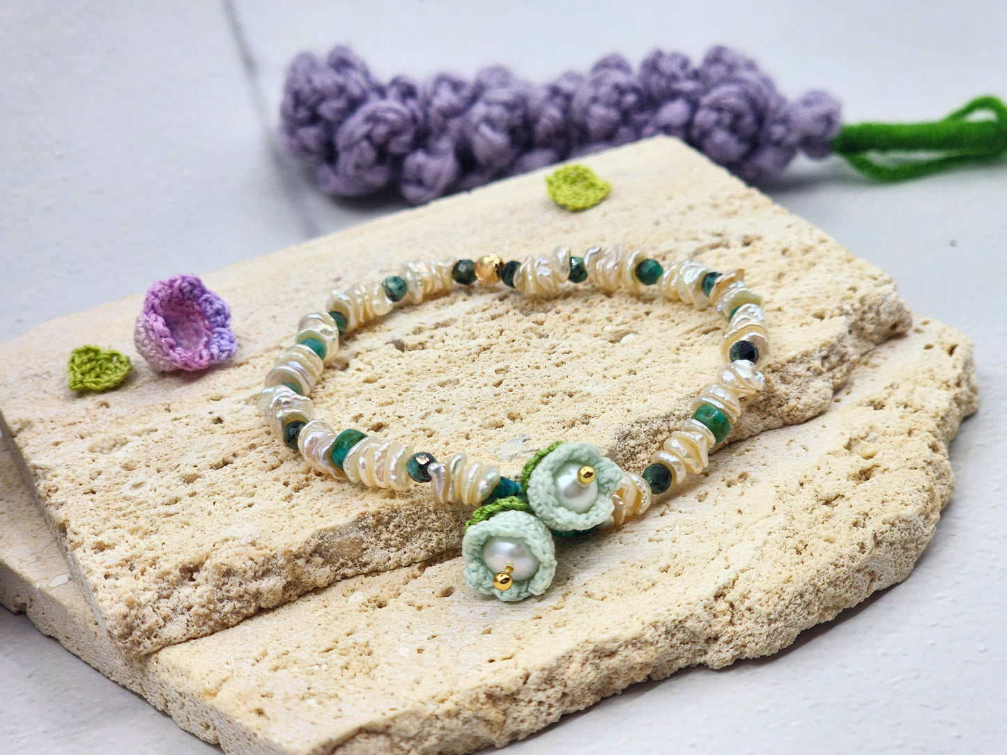 Handcrafted micro crochet Lily of the Valley blooms paired with radiant 4–5mm freshwater Keshi pearls bracelet. Natural Phoenix stones accents.