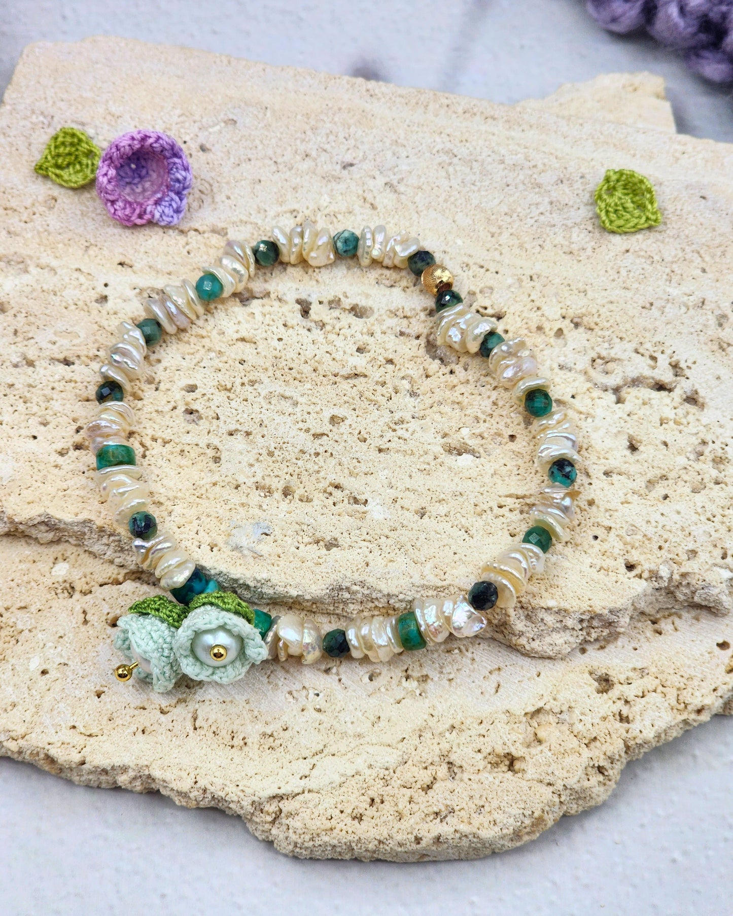 Handcrafted micro crochet Lily of the Valley blooms paired with radiant 4–5mm freshwater Keshi pearls bracelet. Natural Phoenix stones accents.