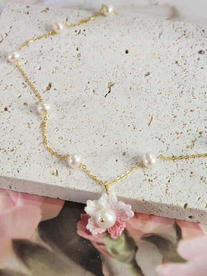 Freshwater Pearls Choker with Micro-crochet Sakura & Pearl pendant close up. Handcrafted and paired with an 18K gold-plated chain.   