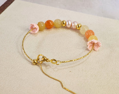 Natural quartz crystals and pearls bracelet with pink handcrafted micro-crochet peach blossoms on 18K gold-plated bracelet.