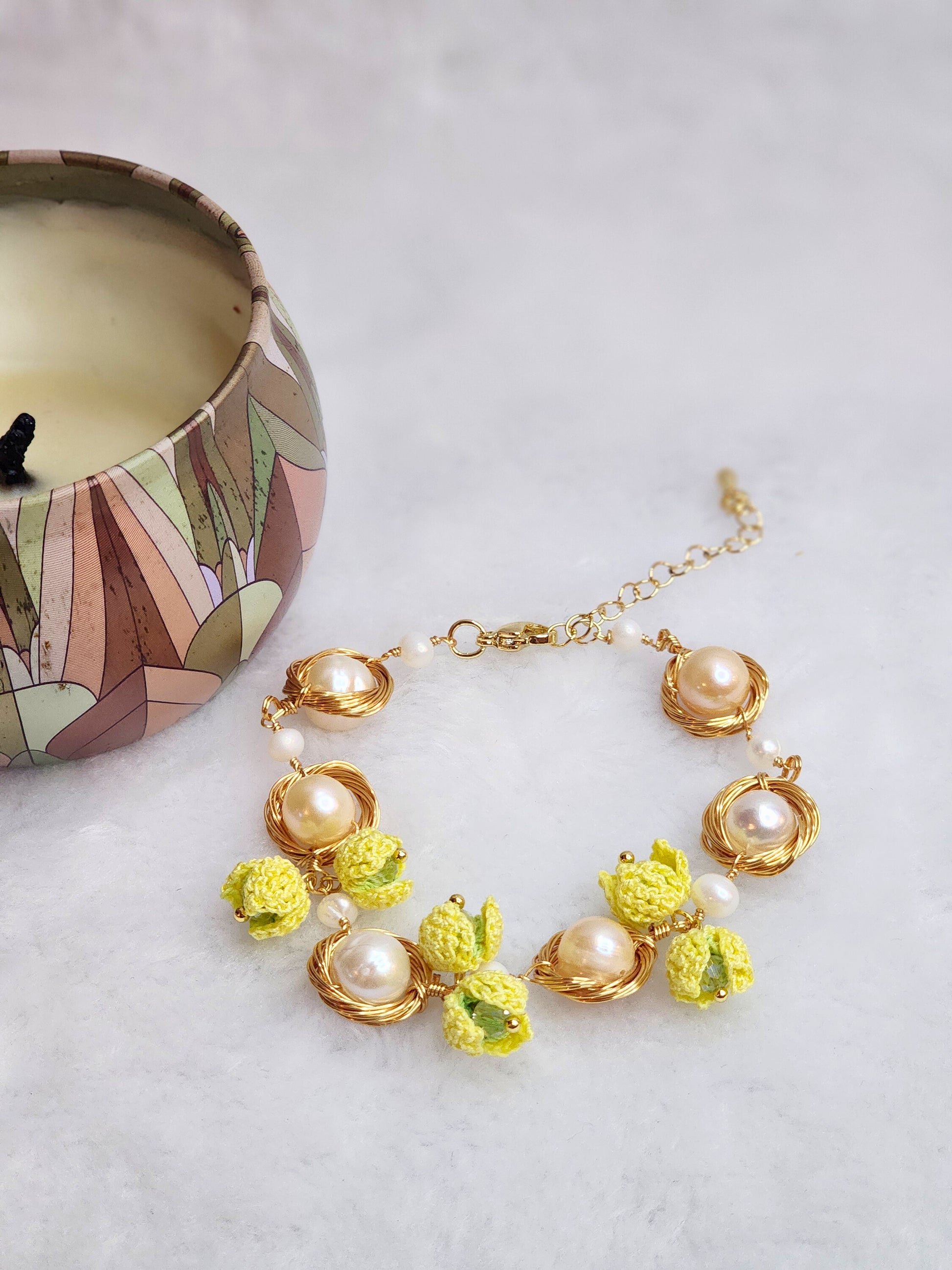Near round 8-9mm pearls bracelet adorned with micro-crochet snowdrops on 18K gold-plated chain. 