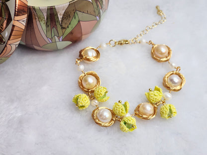 Near round 8-9mm pearls bracelet adorned with micro-crochet snowdrops on 18K gold-plated chain.