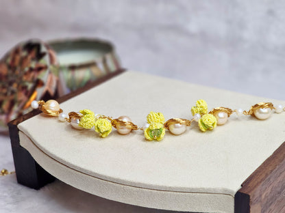 Near round 8-9mm pearls bracelet adorned with micro-crochet snowdrops on 18K gold-plated chain.