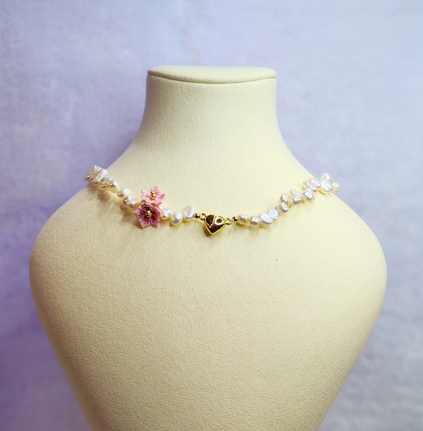 Natural Baroque pearl choker with gold-plated heart charm and pink micro-crochet peach blossoms. 