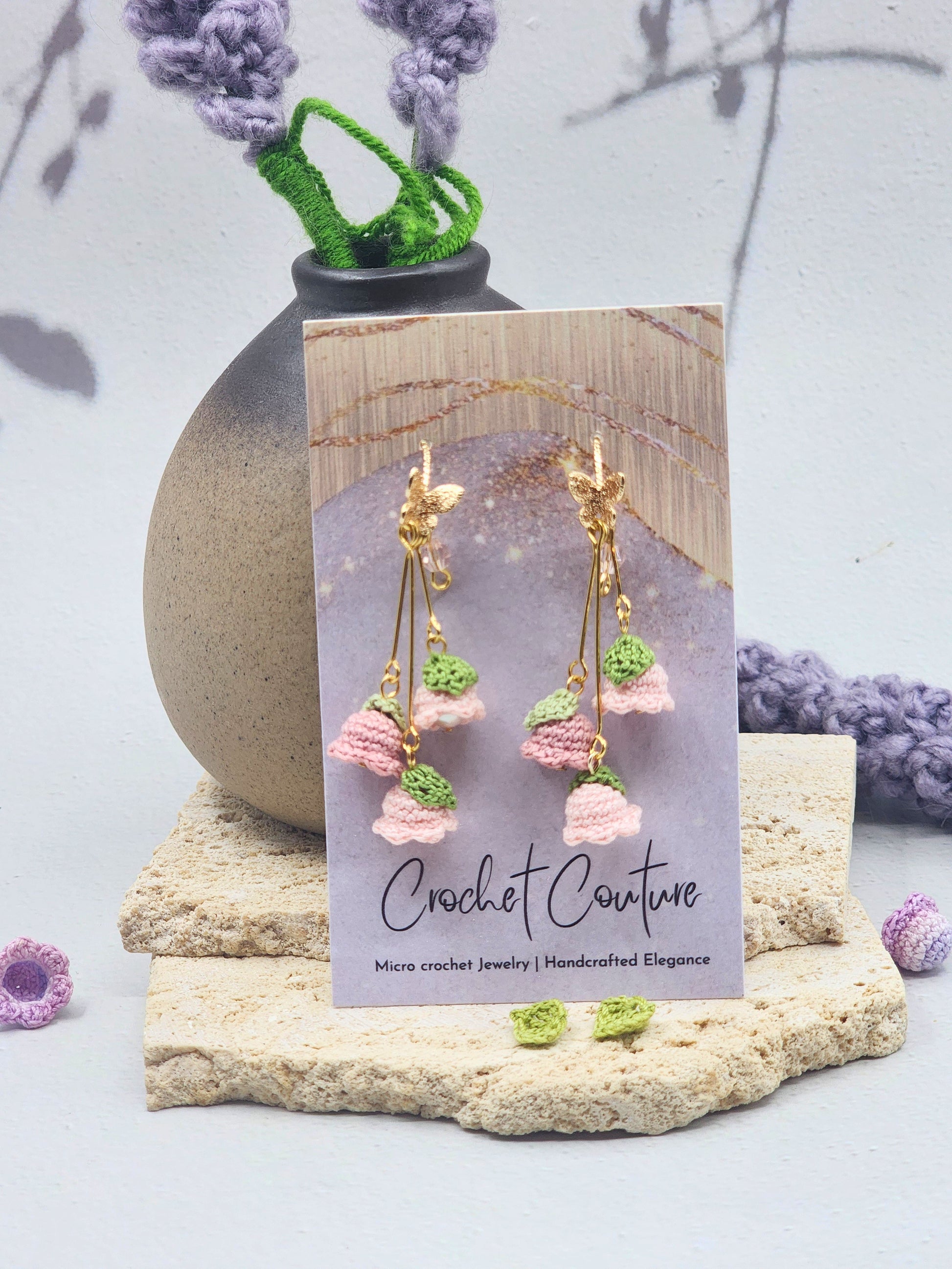 A trio of handcrafted pink micro crochet Lily of the Valley blooms cascade gracefully, each delicately crowned with luminous 6mm Aurora pearls and a sparkling Czech crystal. Finished with 18K gold-plated hooks and findings.