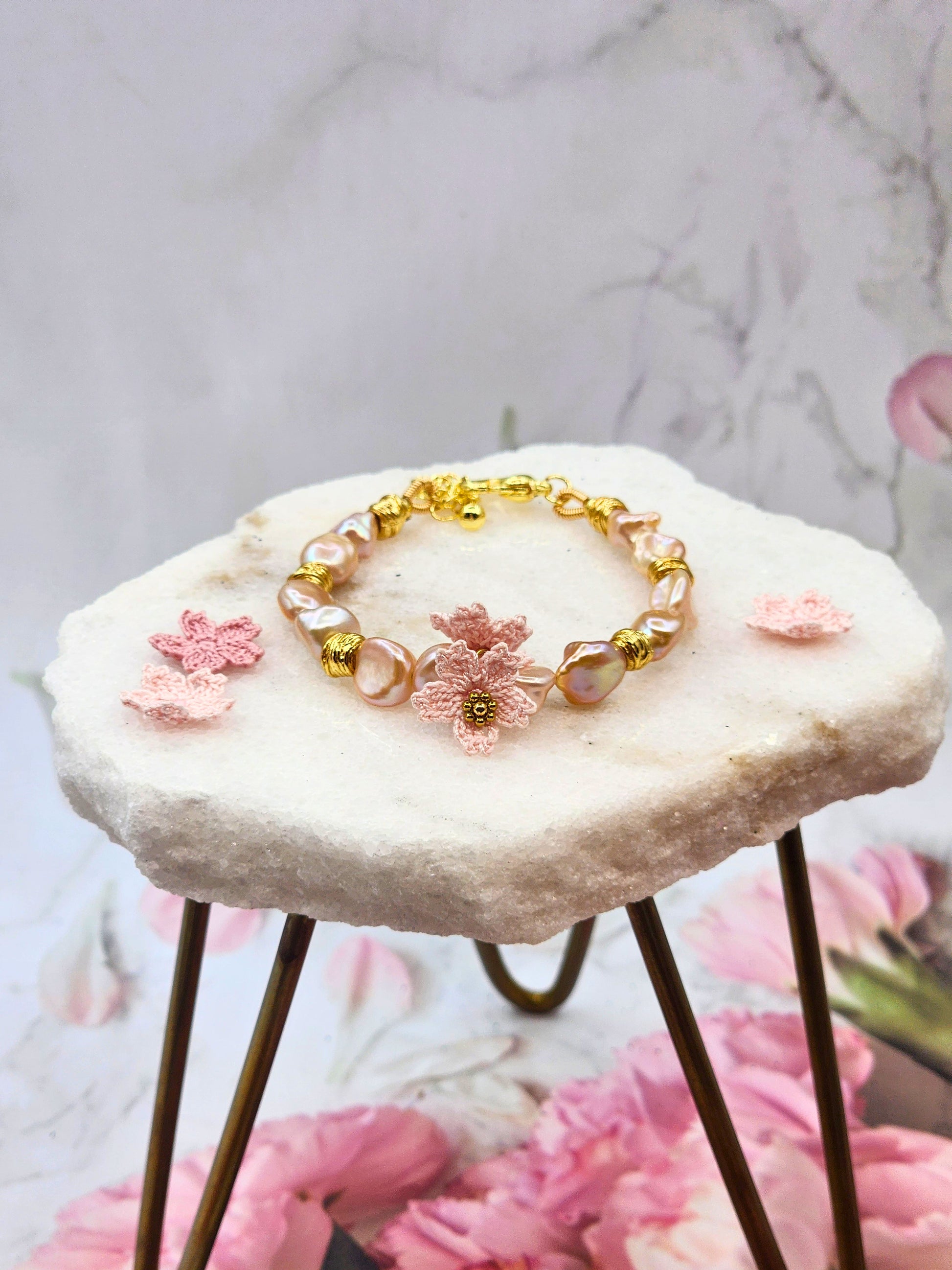 Elevate your style with rare pink-purple radiant Keshi pearls & micro crochet Sakura. 18K gold-plated jewelry wire, spacer beads, & a heart-shaped clasp.