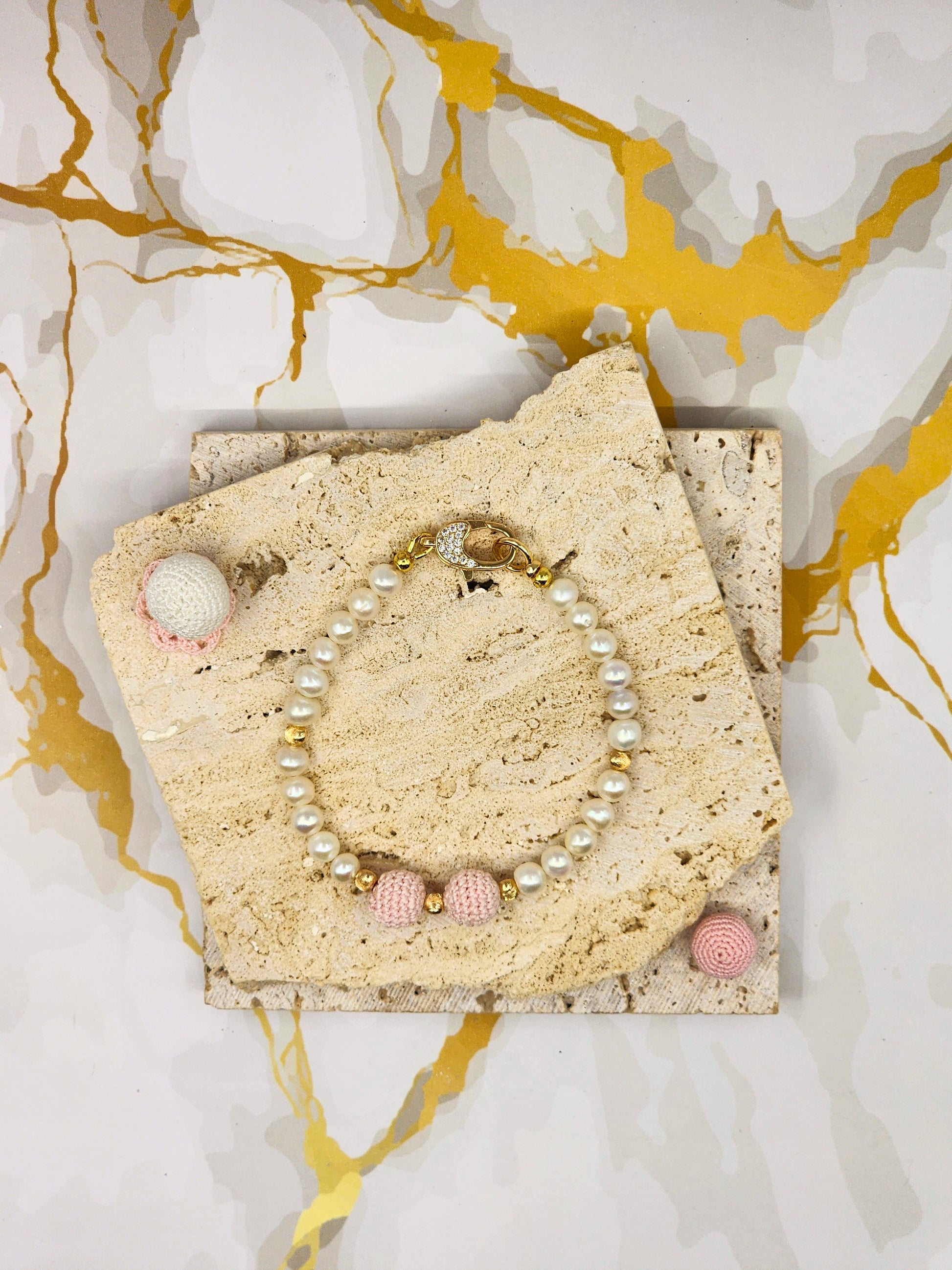 Handcrafted pink 'crochet pearls', beautifully framed by near-round 5–6mm freshwater pearls, chosen for their radiant lustre and smooth, luminous finish. 18K gold-plated accent beads and a clasp adorned with cubic zirconia.
