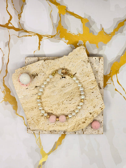 Handcrafted pink 'crochet pearls', beautifully framed by near-round 5–6mm freshwater pearls, chosen for their radiant lustre and smooth, luminous finish. 18K gold-plated accent beads and a clasp adorned with cubic zirconia.