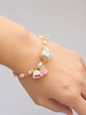 Handcrafted micro crochet Lily of the Valley blooms bracelet. Delicate 4-5mm pink-purple freshwater Baroque pearls decorate an 18K gold-plated chain. At its heart sits an exceptional > 10mm Baroque pearl. 