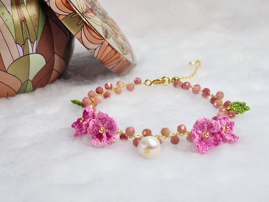Natural Rhodochrosite crystal and pearl bracelet with handcrafted pink micro-crochet peach blossoms on an 18K gold-plated bracelet.