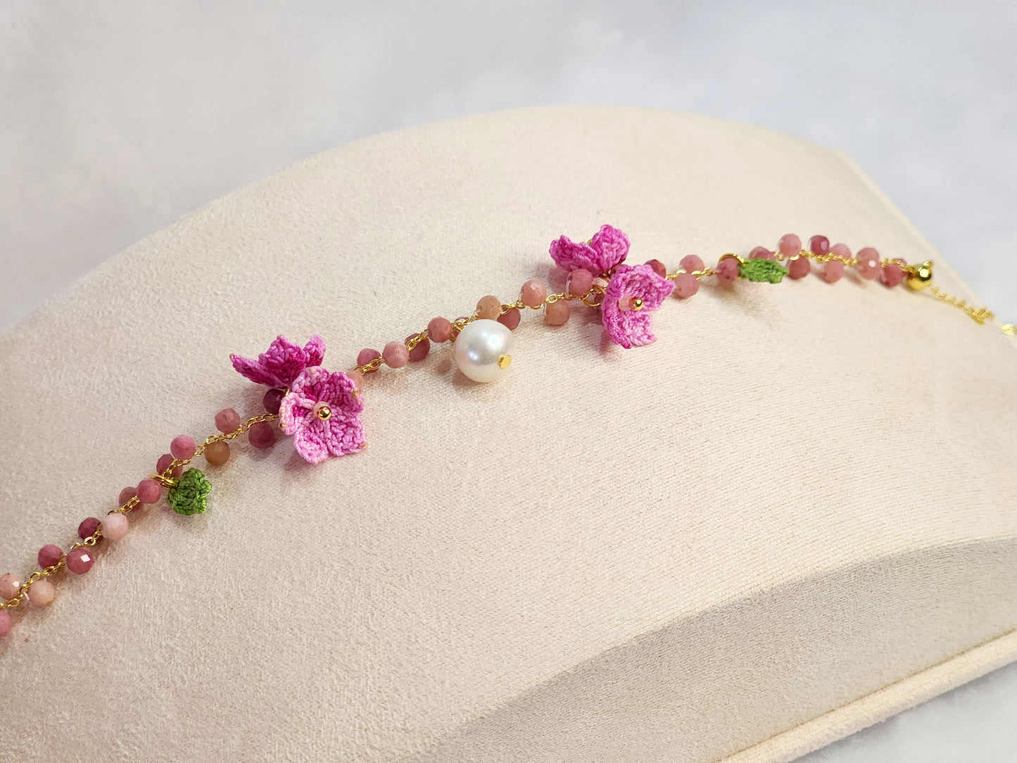 Natural Rhodochrosite crystal and pearl bracelet with handcrafted pink micro-crochet peach blossoms on an 18K gold-plated bracelet.