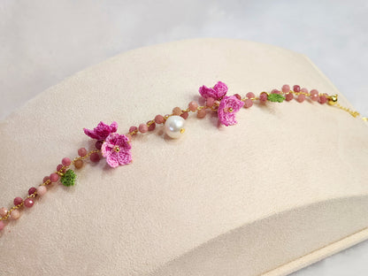Natural Rhodochrosite crystal and pearl bracelet with handcrafted pink micro-crochet peach blossoms on an 18K gold-plated bracelet.
