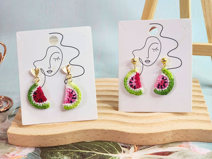 A pair of watermelon slice micro-crochet earrings handcrafted with ultra-fine lace yarn and 18K gold-plated studs