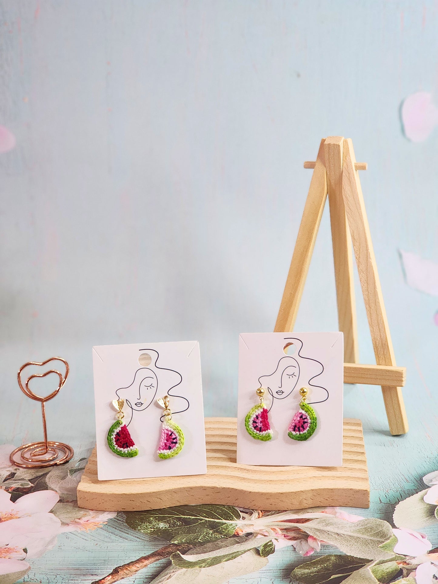 A pair of watermelon slice micro-crochet earrings handcrafted with ultra-fine lace yarn and 18K gold-plated studs